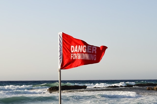 Red danger flag on a beach. 
