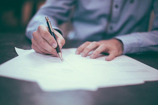 Man at table signing papers