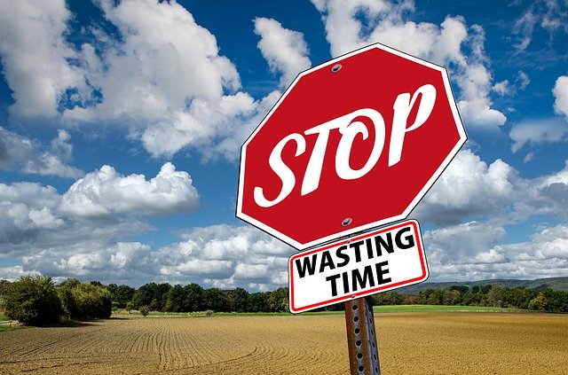 stop sign with 'wasting time' underneath