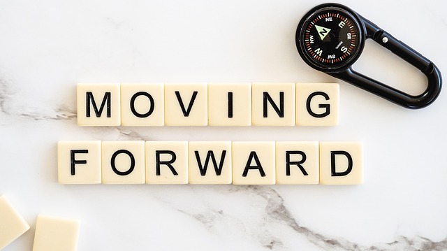 Scrabble pieces saying 'moving forward'
