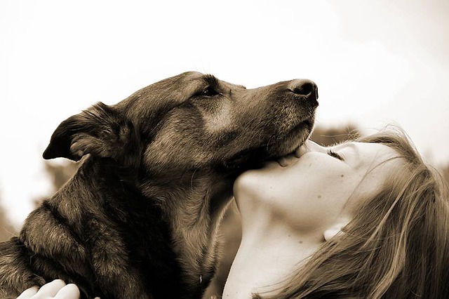 Women giving dog a kiss.